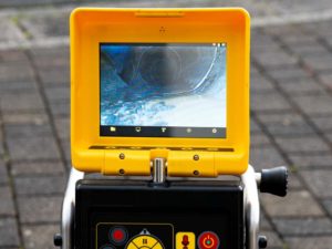 technician looking at the live feed from a sewer camera inspection